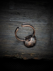 Detail of vintage adjustable ring with natural raw stone on rustic dark wood background