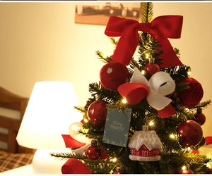 Close-up of mini Christmas tree with red felt bows and festive bulb ornaments