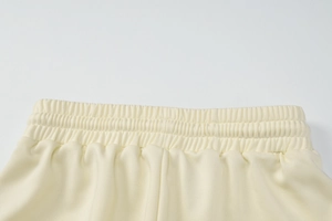 Détail de la taille élastique d'un pantalon en tricot jaune clair avec cordon de serrage