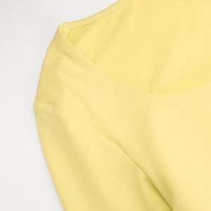 Detailed close-up of yellow square neck top showing fine stitching and fabric texture