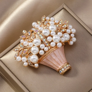 Macro view of floral basket brooch with pink enamel, white pearls and sparkling crystals