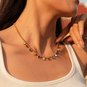 Close-up of gold chain necklace with colorful round crystals on model's neck