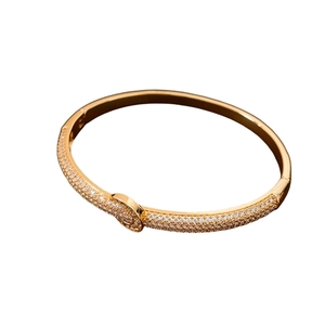 Minimalist 18K gold plated bangle featuring a sparkling white zircon knot design