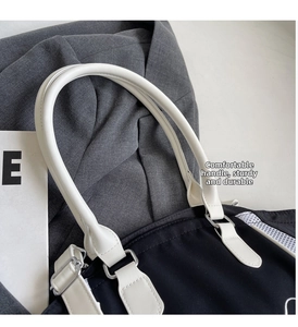 Detail of durable white leather handles and silver metal hardware on a bowling bag