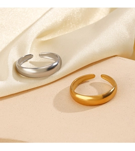 Close-up of gold and silver open rings with polished smooth finish on silk fabric