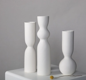 Close-up of white ceramic vases with ribbed textures for modern Nordic home decor