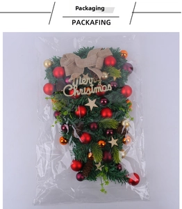 Detail of Christmas teardrop swag in polybag with ornaments, pinecones and burlap bow