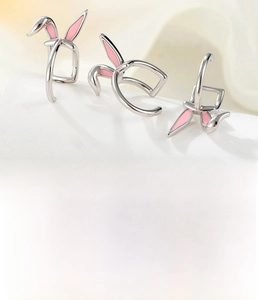 Detail of silver bunny ear ear cuffs made of titanium steel with pink enamel and zircons