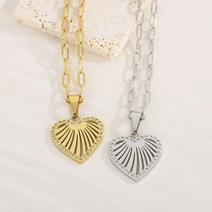 Detailed shot of gold and silver heart pendants with hollow sunburst and crystal inlay