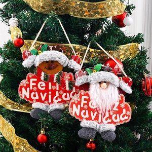 Christmas plush Santa and reindeer ornaments hanging on a decorated festive tree