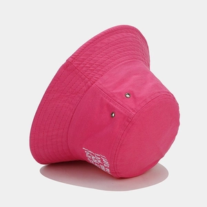 Détail d'un chapeau bob rose en coton avec broderie blanche et œillets métalliques