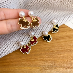 Detailed macro view of rocking horse earrings featuring pearls and sparkling rhinestones