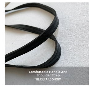 Dettaglio della comoda tracolla in pelle nera con cuciture precise sulla borsa tote