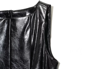 Dettaglio del top nero senza maniche in ecopelle lucida con chiusura lampo metallica