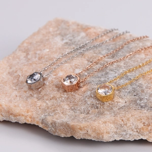 Elegant hexagon zircon pendant necklaces in silver, gold, and rose gold on stone