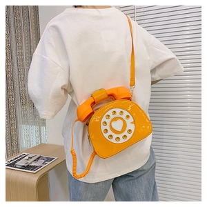 Creative yellow telephone shaped crossbody bag with dial details shown on model