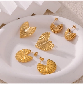 Detailed macro view of French vintage gold-plated pleated fan-shaped earrings with zircons