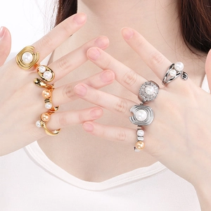 Detail of square textured gold and silver rings with inlaid pearls on a model's hand
