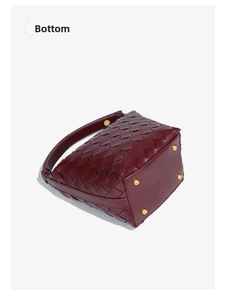 Detail view of woven leather bucket bag bottom with protective gold metal feet studs