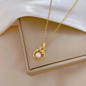 Luxurious gold leaf necklace with pearl and sparkling zircons on silk background