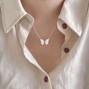 Minimalist 925 sterling silver butterfly pendant necklace on model with white shirt