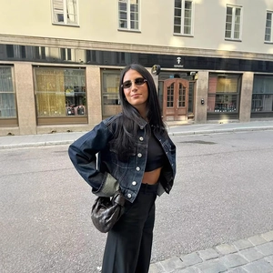 Veste en jean chic avec pantalon large noir et sac à main en cuir tressé en ville