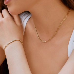 Detail of gold necklace and bracelet set with pavé crystals and paperclip chain links