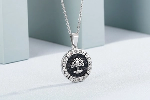 Macro view of silver tree of life pendant with black inlay and sparkling crystal border