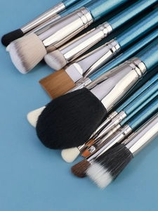 Dettaglio di 12 pennelli da trucco professionali con manici blu glitterati e setole morbide