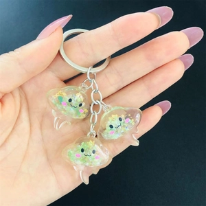 Close-up of translucent resin jellyfish keychains with sparkling glitter and gold foil