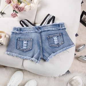 Dettaglio di pantaloncini di jeans strappati con orli sfrangiati e spalline con lettere
