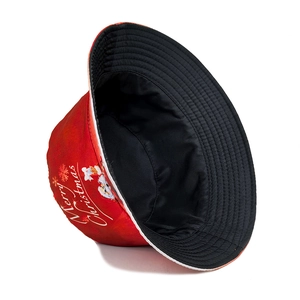 Close-up of red Christmas bucket hat with Santa print and reversible black lining
