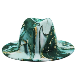 Detail of artistic marble print on a wool fedora hat with gold accents and flat brim
