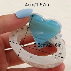 White marble pattern hair claw clip with rhinestones and blue heart accent detail