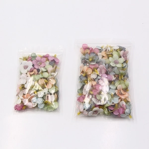 Close-up of assorted colorful 2cm mini silk daisies packed in transparent resealable bags