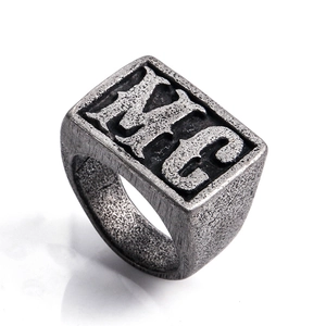 Macro view of men's vintage stainless steel ring with embossed NYC lettering on rectangular face