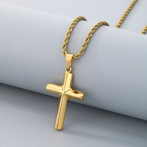 Detailed view of a polished gold cross pendant with a thick twisted rope chain