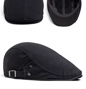 Detail view of black cotton flat cap showing adjustable side buckle and interior lining