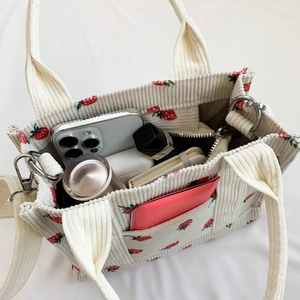 Off-white corduroy tote bag with strawberry embroidery showing spacious interior capacity