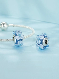 Macro view of blue glass flower charm with S925 silver core for DIY bracelet