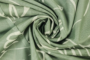 Macro shot of breathable mesh fabric showing green and white floral print texture