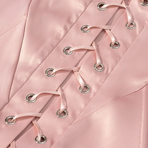 Detail of pink satin corset top with silver metal eyelets and matching ribbon lace-up