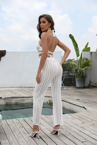 Detalle de top de ganchillo blanco y pantalones de playa acampanados de tiro alto