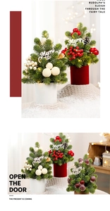 Close-up of mini LED Christmas trees with snowy berries and Merry Christmas signage
