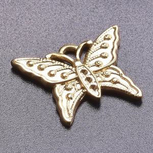 Detailed macro view of a 18k gold plated butterfly pendant with embossed metal texture