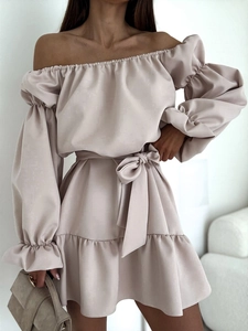 Détail de robe courte satinée à épaules dénudées avec manches bouffantes et nœud