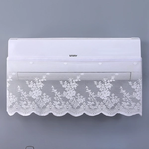 Close-up of white lace air conditioner cover with floral embroidery and wavy edges
