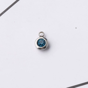 Macro detail of 6.5mm stainless steel pendant with round blue faceted birthstone charm