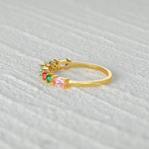 Macro detail of S925 silver gold-plated ring showing colorful gemstones and engraving