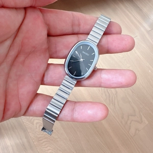 Detail of the oval black dial and silver metallic link bracelet on this ladies' watch